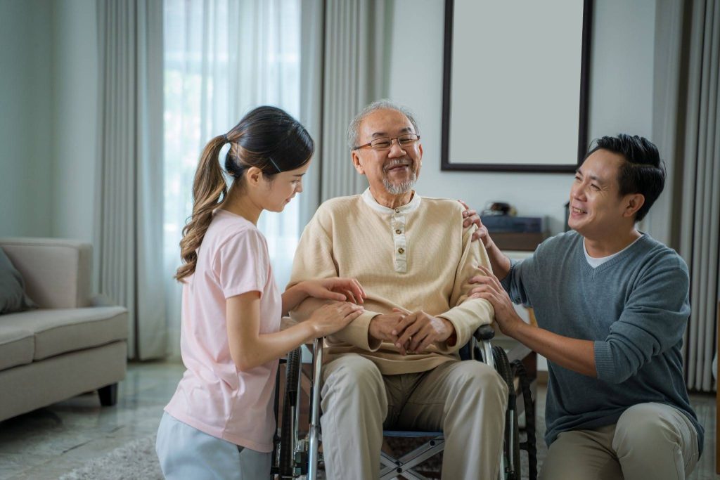 Adult daughter helping her elderly father with a daily task at home in Singapore